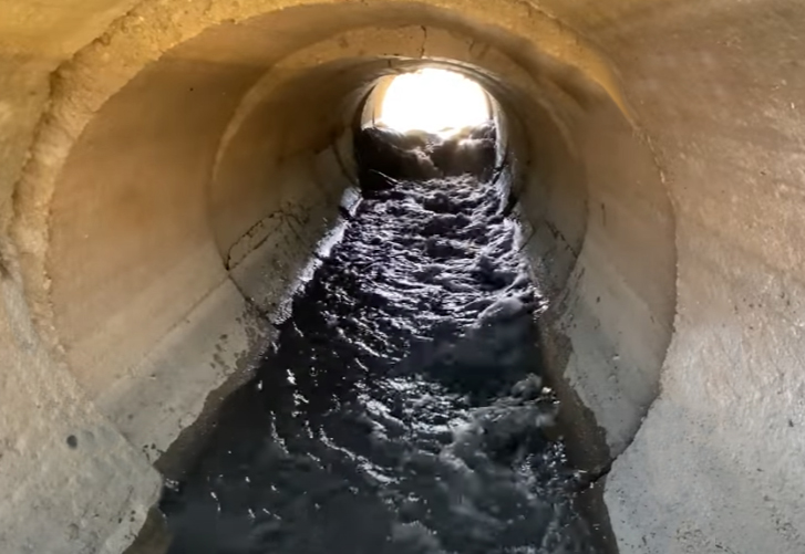Water flowing through a culvert after a partial beaver dam removal