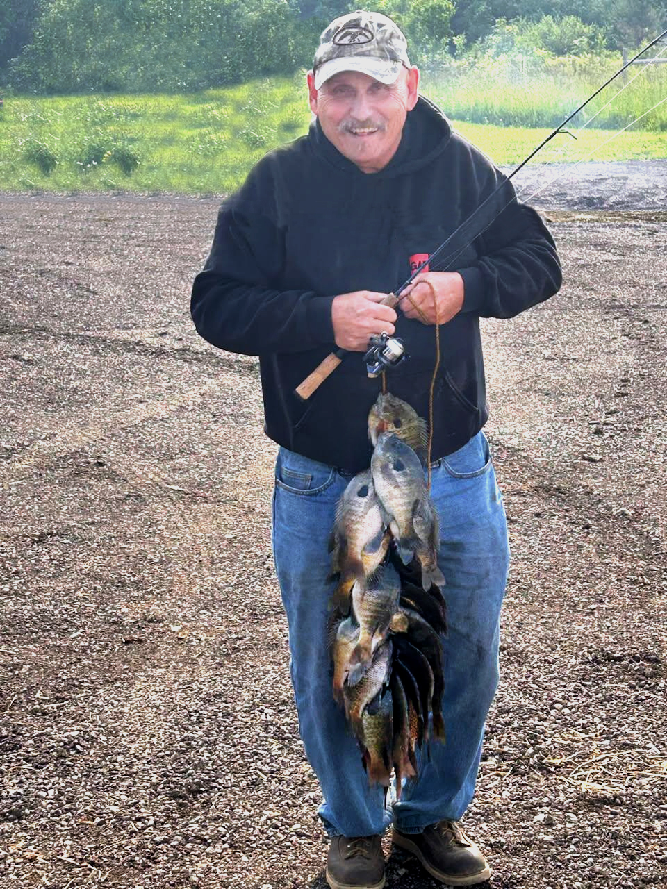 Ken Dalton holding stringer of keeper bluegill caught in Michigan inland lake.