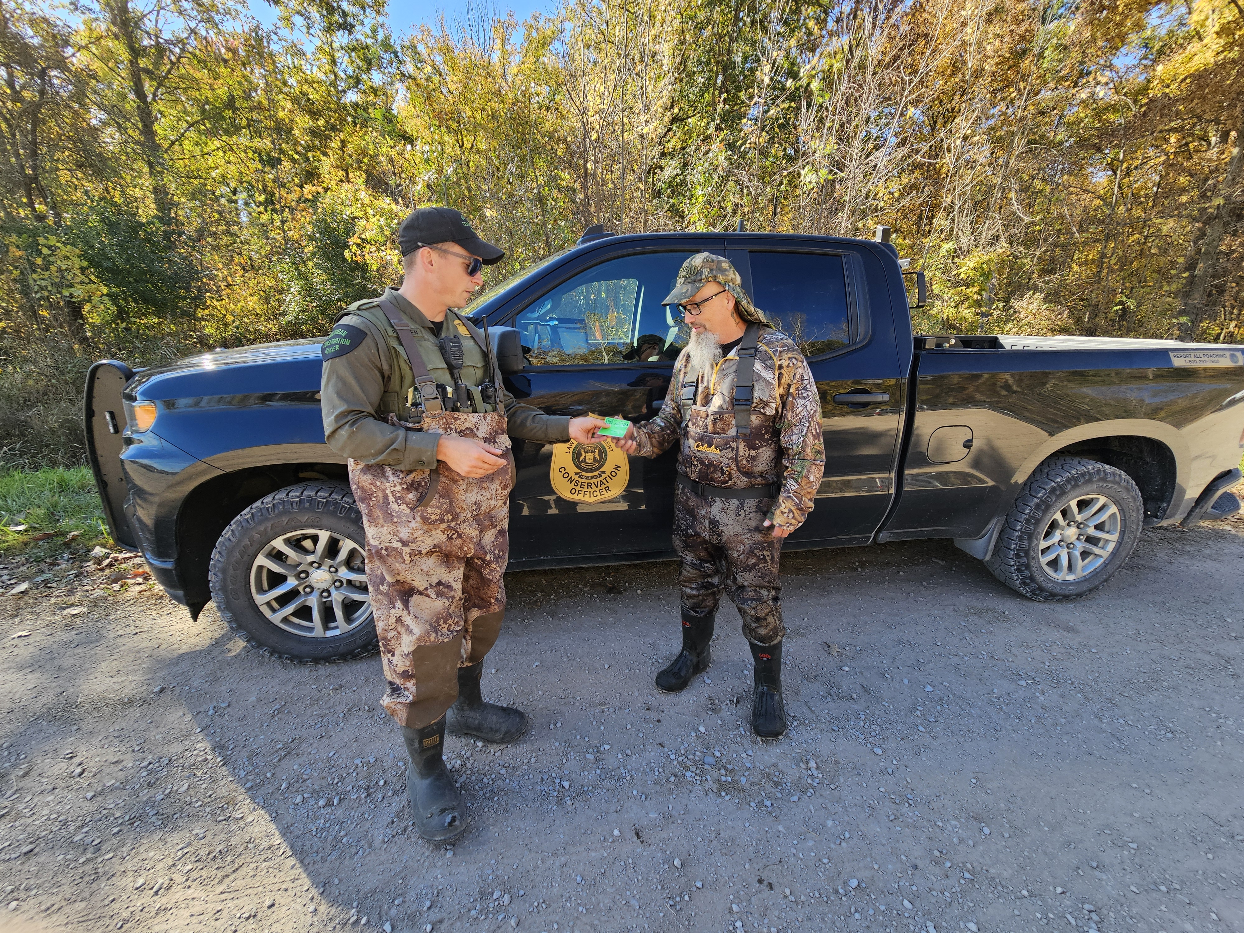 A waterfowl hunter has his license checked by a Michigan DNR Conservation Officer